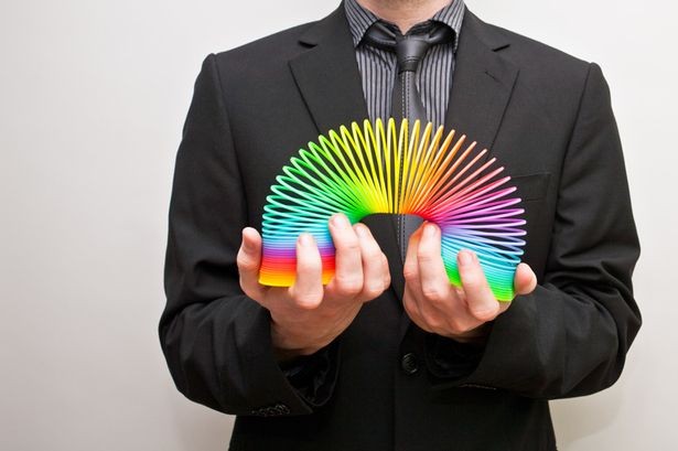 Business man holding rainbow coloured slinky